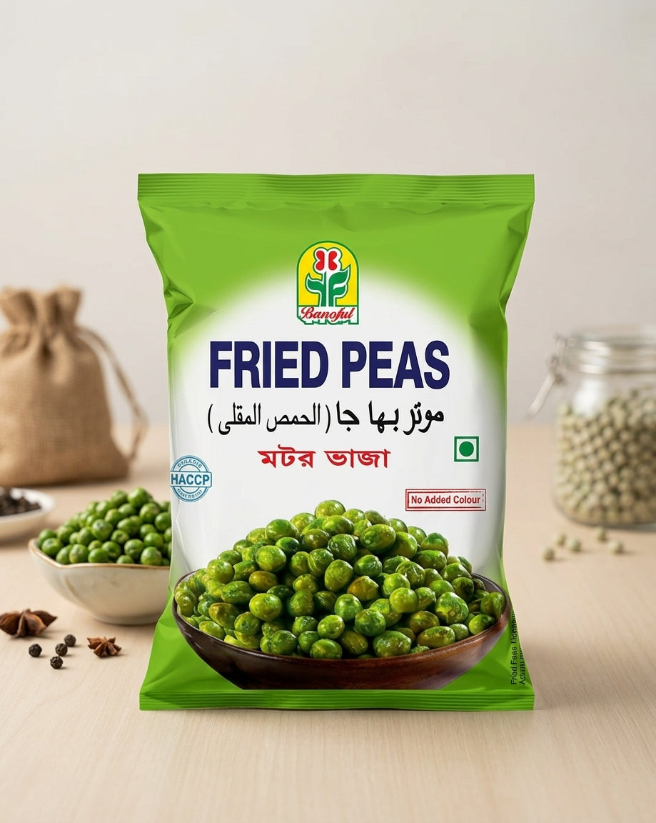 A bag of Banoful Brand Fried Peas standing on a light wooden surface, with bowls of whole green peas and spices in the background.