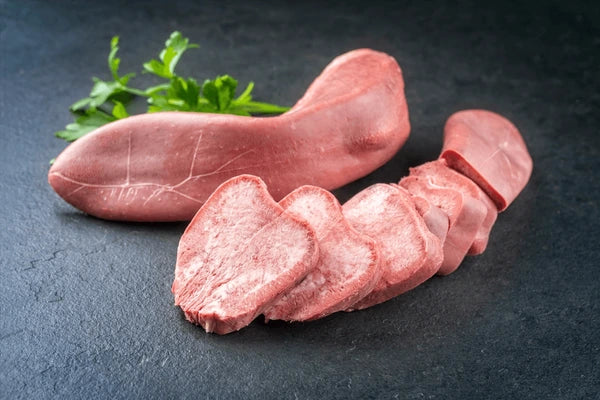Raw sausage with slices on a dark surface