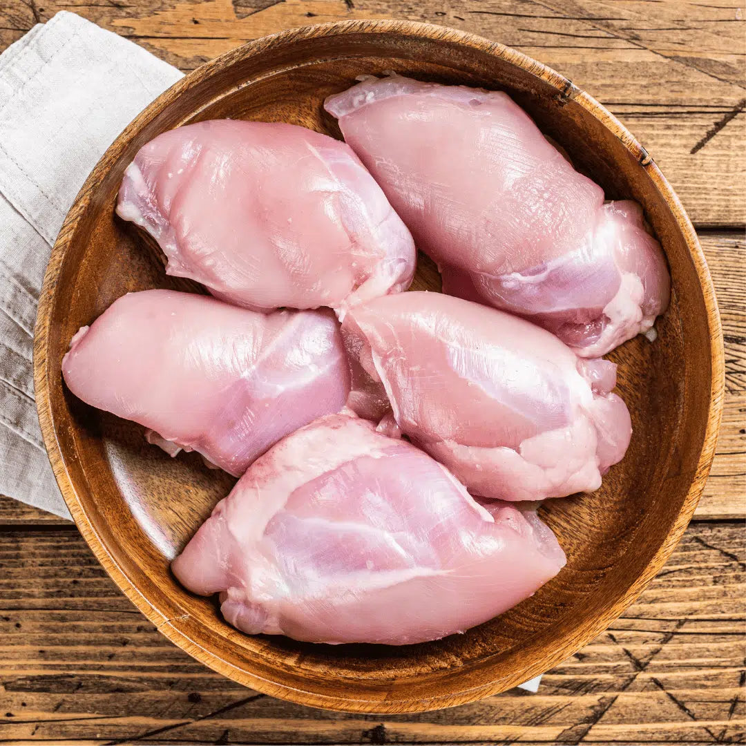 Raw Chicken Thighs (Boneless & Skinless)  Fresh Halal Chicken Thighs  Zabiha Halal  in a wooden bowl on a wooden surface
