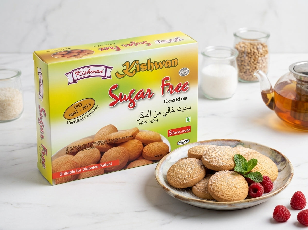 A box of Kishwan Sugar Free Cookies displayed on a light marble surface next to a plate of cookies with raspberries and mint, with small jars of ingredients in the background.