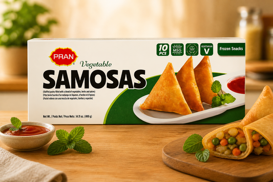 Box of Pran Vegetable Samosas on a wooden table with samosas and dipping sauce.