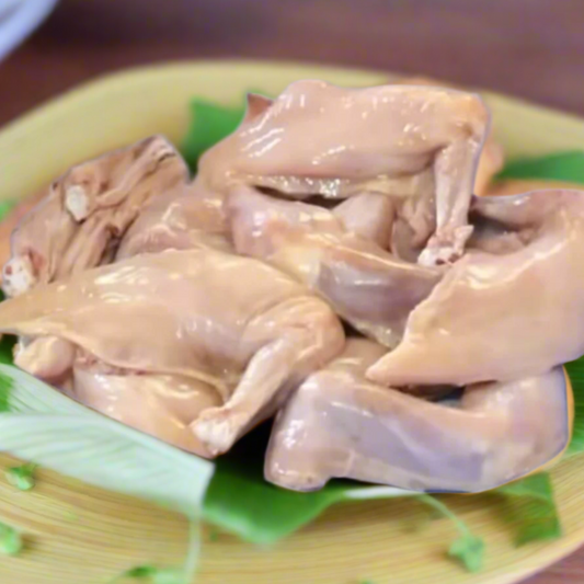 Raw chicken  on a green leafy base with a wooden surface