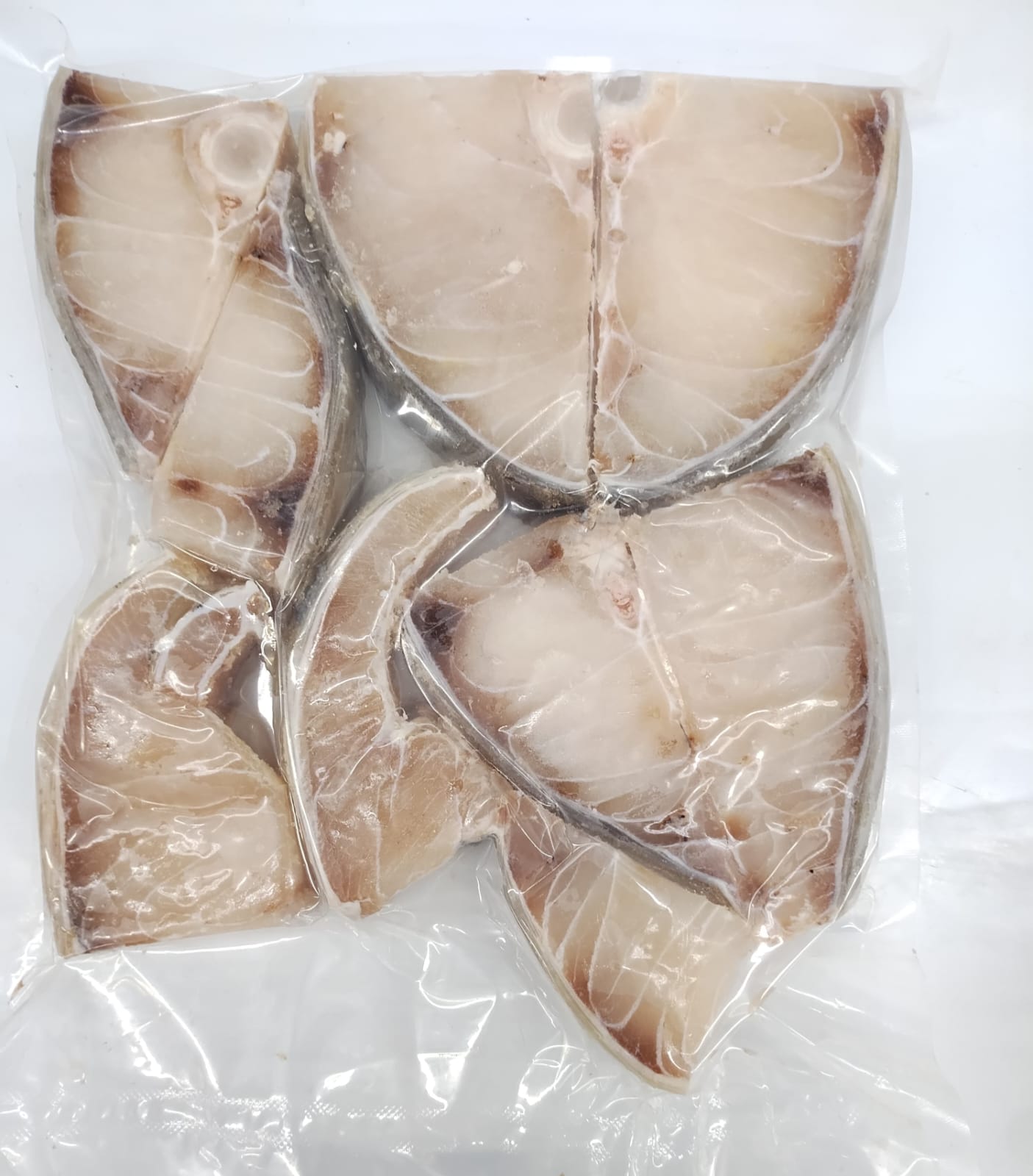 Packaged fish fillets in a clear plastic wrap on a white background