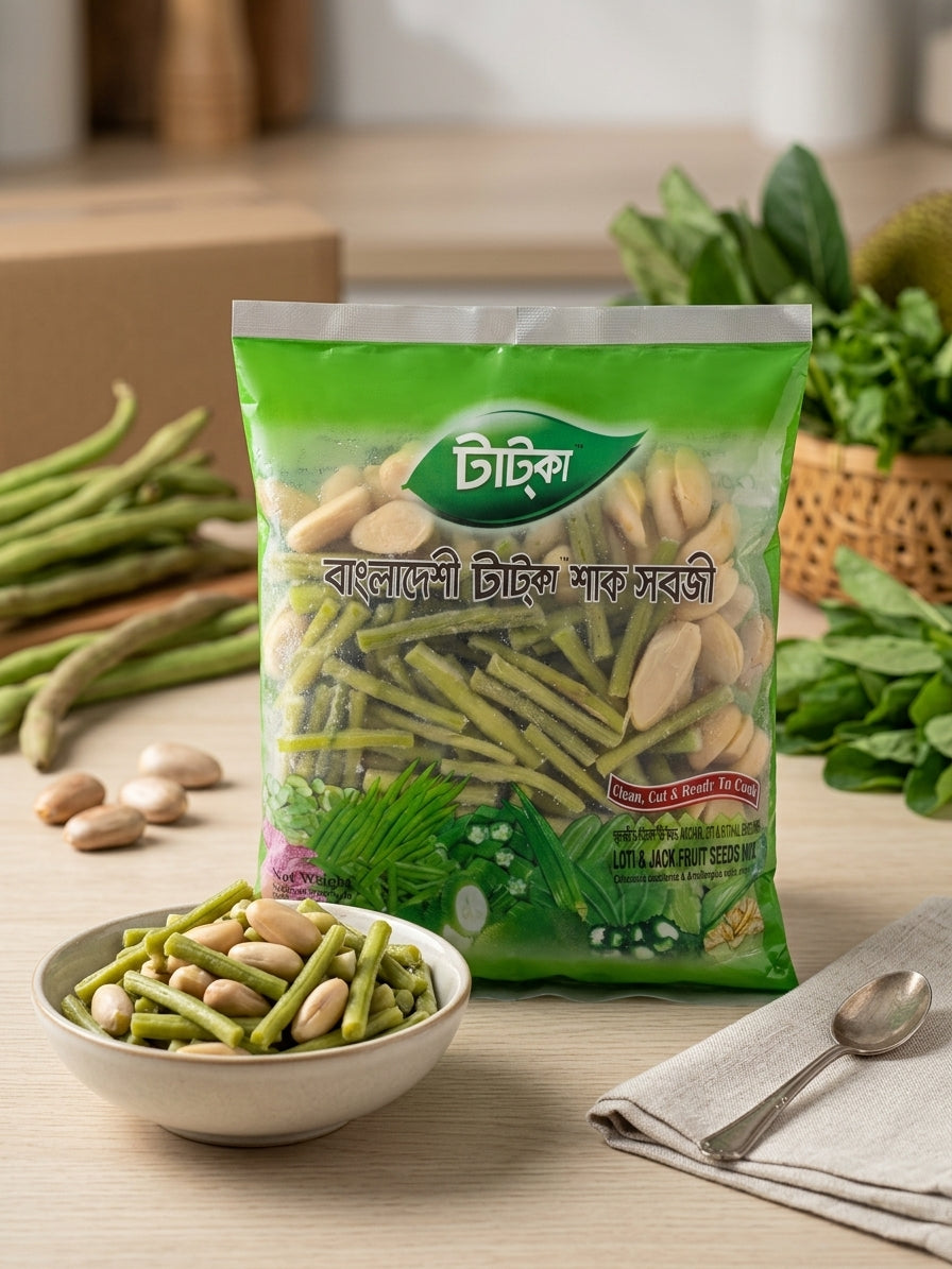 A bag of Tatka Bangladeshi tatka shak shobji (Kochur loti & kathal bichi) displayed on a wooden table with a bowl of the prepared food, green beans, and spinach in the background